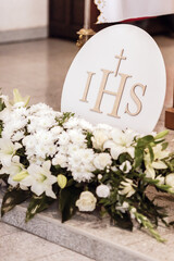 IHS Monogram Displayed in Church During First Holy Communion Ceremony