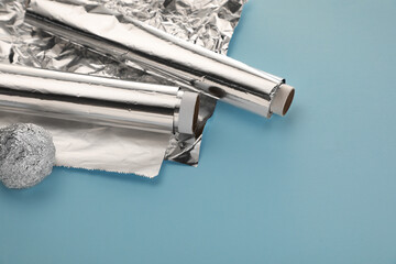 Aluminum foil on light blue background, above view. Space for text