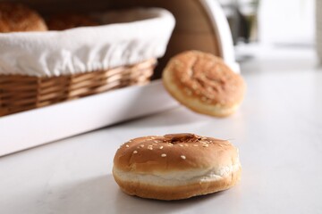 Cockroach crawling on bun with sesame seeds on light table