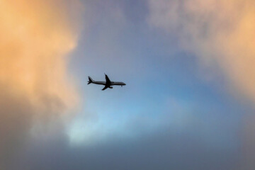 Silhouette of a commercial airplane flying through a dramatic sky