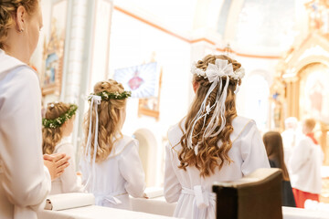 Beautiful Communion Hairstyle with Green Leaf Wreath on Girl During Holy Mass
