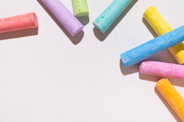 Multicolored bright crayons for drawing on light gray background flat lay top view. Children's chalk close-up. Concept of creativity, child development, back to school