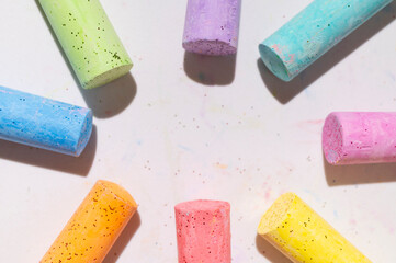Multicolored bright crayons for drawing on light gray background flat lay top view. Children's chalk close-up. Concept of creativity, child development, back to school