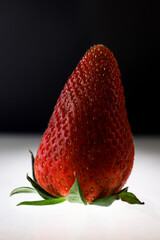 Minimal Fruit. Fragola su sfondo nero e base bianca.