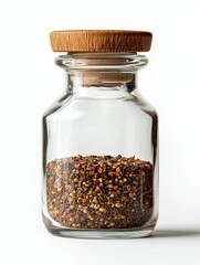 Small Glass Jar of Brown and Tan Seeds on White Background