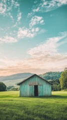 Obraz premium Rustic Barn Standing in a Lush Green Meadow at Sunset with Rolling Hills and Cloudy Sky in a Vertical Composition