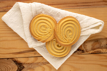 Shortbread sweet cookies with kitchen utensils on a wooden table, close-up, top view.