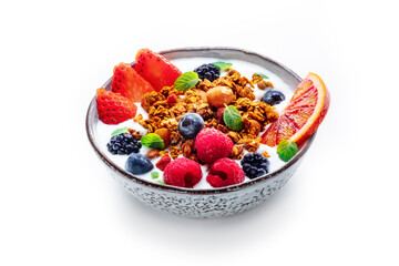 Granola with yogurt and fresh fruit. Organic gourmet muesli with strawberry, blueberry, raspberry, mint, and orange, on a white background