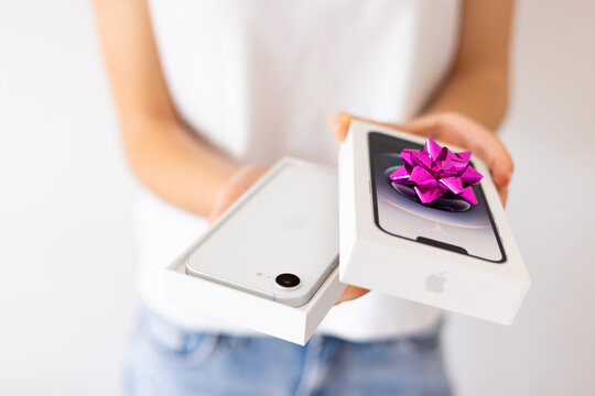 Madrid, Spain - April 13, 2025: Person unboxing the gift, the latest Apple iPhone 16e smartphone.
