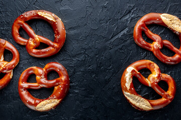 Pretzel or Bretzel, traditional German beer snack, overhead flat lay shot on a black background with copy space, menu banner design
