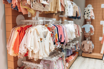 Inside the kid's clothing store. Shirts and sweaters are hanging