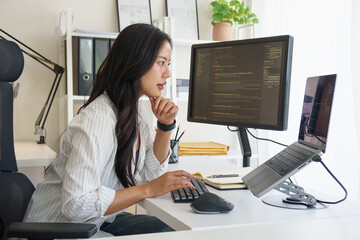 Software developer working on coding project with multiple monitors in modern home office..