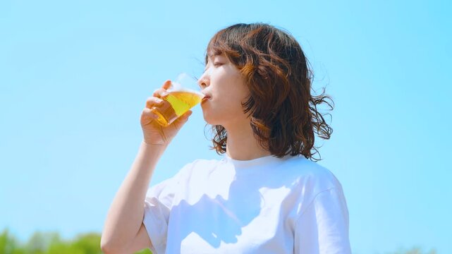 夏の青空とビールを飲む女性