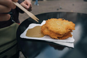 Crispy potato pancakes served with applesauce on a street food table