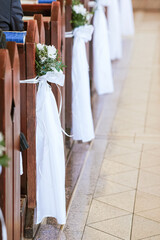 Flowers and Green Branches Decorating Church Pews for First Holy Communion