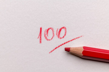 red 100 full mark with pencil written in red ink on white paper. educational concept