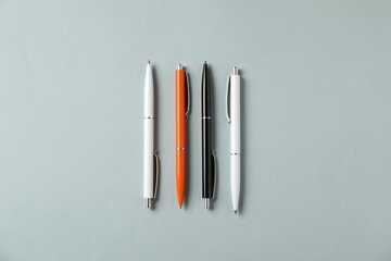 Stylish pens on grey background, flat lay