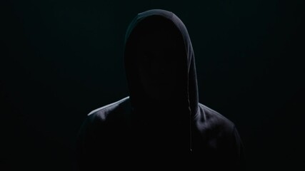 Enigmatic Figure Shrouded in Hooded Shadows