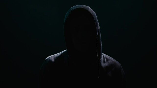 Enigmatic Figure Shrouded in Hooded Shadows