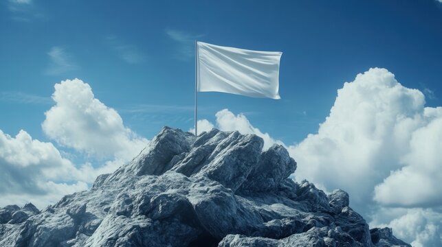 A blank flag waving atop a rocky mountain peak.