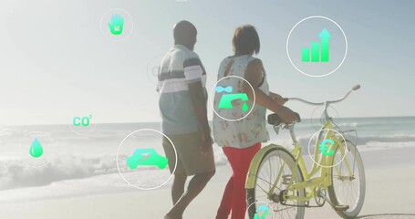man walking alongside woman pushing bicycle on beach, showing floating environment bar graph icons - Powered by Adobe