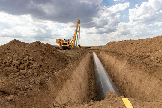 Large Pipeline Construction. Heavy Machinery Installing Underground Gas or Oil Pipeline. Infrastructure Development and Energy Industry Concept.  Industrial Infrastructure Project