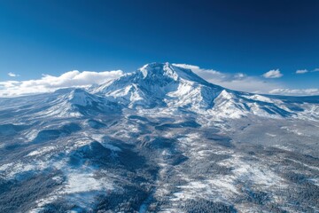Snowy mountain peaks rise majestically under a clear blue sky in winter’s embrace