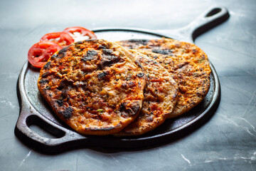 Amritsari kulcha is a crispy, flaky stuffed flatbread from Punjab, filled with spiced mashed potatoes or paneer, baked in a tandoor, and served hot with kabuli chana masala and salad
