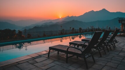 Obraz premium Tranquil pool, loungers, mountain views, sunset glow