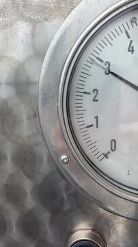 Meedle of a pressure gauge moves up to 3 atmospheres and returns, showing dynamic measurement of air pressure in vehicle tire