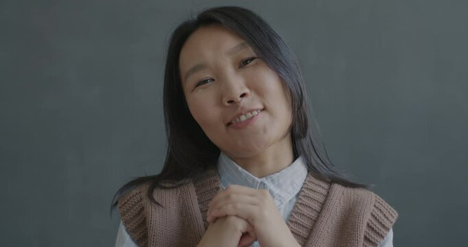 Portrait of young Asian woman talking and gesturing looking at camera on black color background. Online video call and vlogging concept.