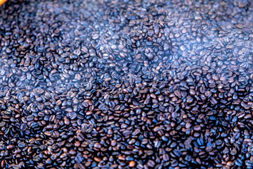 Roasted coffee beans, just came out of the fire, hot, smoke coming out