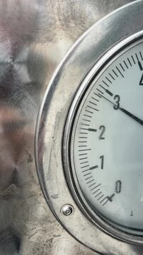 Manometer needle rising to 3 atmospheres and dropping back down, close up view of tire pressure measurement process
