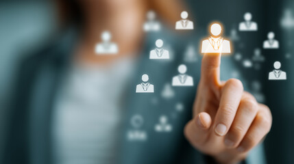 Abstract representation of a hand selecting a digital person icon among multiple figures in a professional setting with a blurred background
