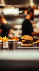 Double cheeseburger and fries on a counter in a restaurant kitchen with chefs in the background