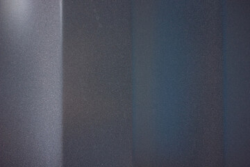 Close-up abstract view of a dark textured surface with vertical lines and color variations....