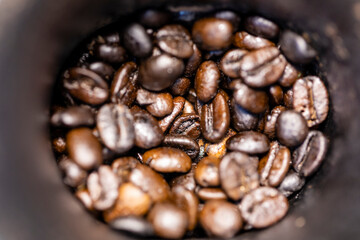 Roasted coffee beans inside in the manual grinder