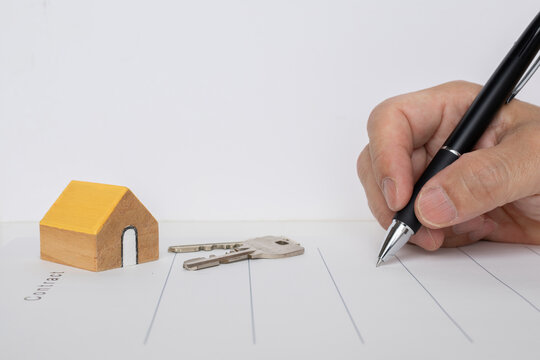 不動産契約でサインする人の手元