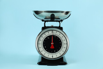 One mechanical kitchen scale on light blue background