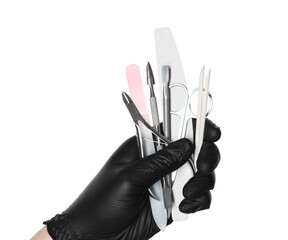 Woman with manicure tools on white background, closeup