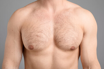 Young man with hairy chest on light grey background, closeup. Epilation procedure