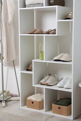 Shelving unit with different footwear and accessories indoors. Shoe storage