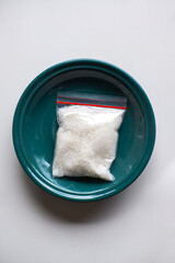 Granulated sugar contained in small plastic clips