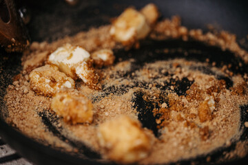 Melting brown sugar and butter in pan for dessert.
