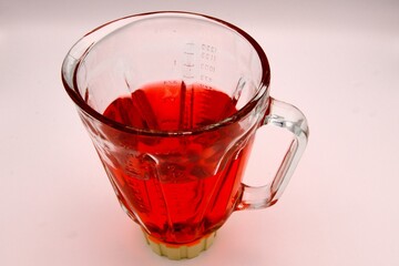 a blender with a red colored drink