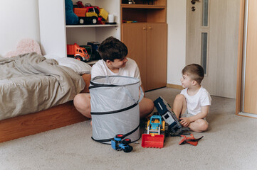 Older brother playing with younger sibling in cozy kids room. Emotional bonding, play-based learning and family values in a candid real-life scene.