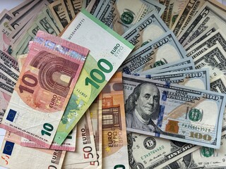 Close-up shot of Euro and US Dollar banknotes scattered on a flat surface, symbolizing global finance and currency exchange.