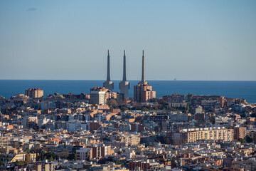Naklejka premium Three towering chimneys overlooking the coastal skyline