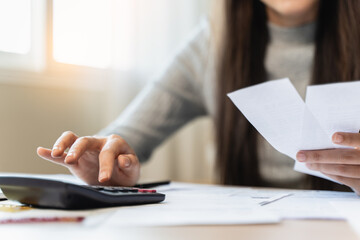 Financial owe, hand of asian woman sitting, holding credit card, stressed by calculate expense from...