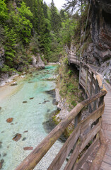 wooden walkway and stream with clean transparent water in a gorge in the middle of mountains